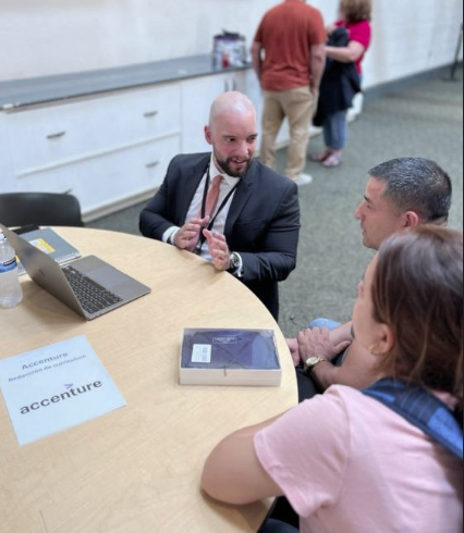 Joaquin Wilson, at an Accenture-branded table, advising two participants on workforce entry strategies during a SAMU enablement session.